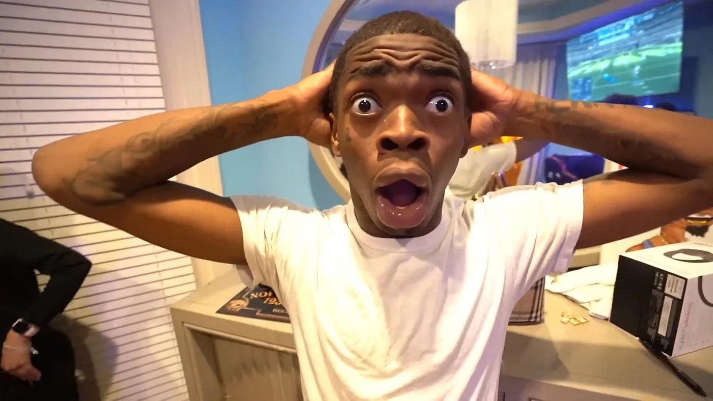 A man holding his head, mouth open in shock